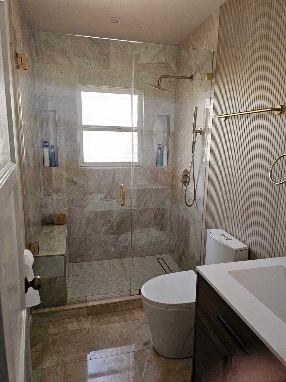 Completed shower renovation with frameless glass door by Green Rise Builders